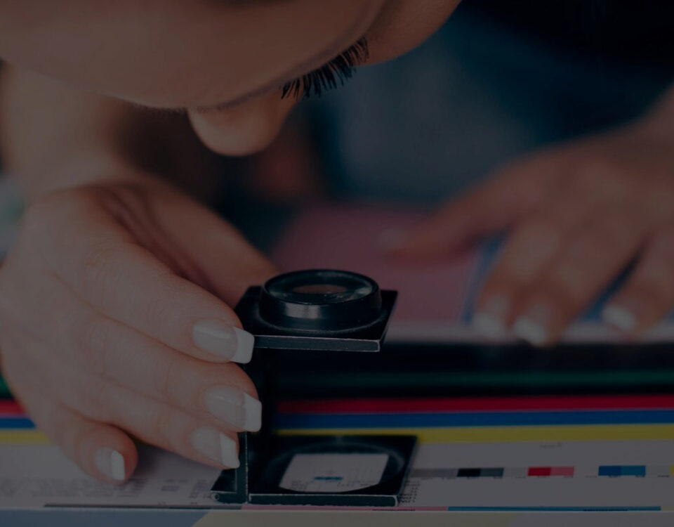 designer inspecting document print magnifying lens