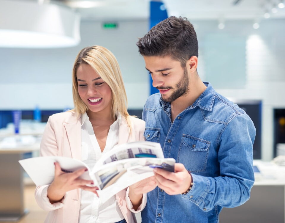 man and woman employees in corporate office reviewing print documents