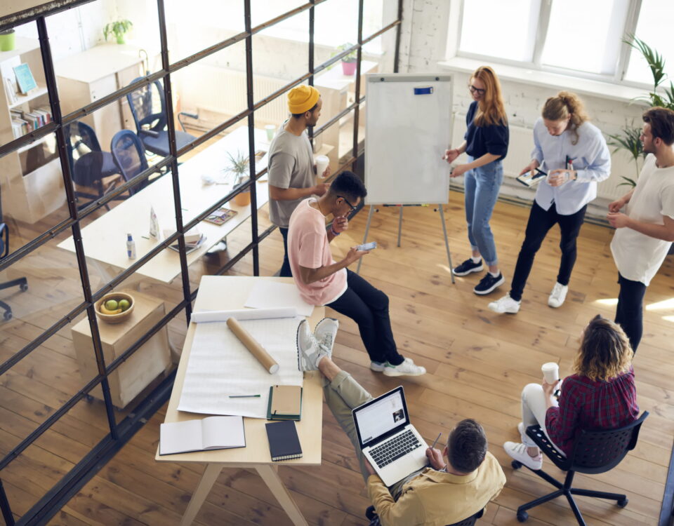 team of trendy employees in fashionable meeting room