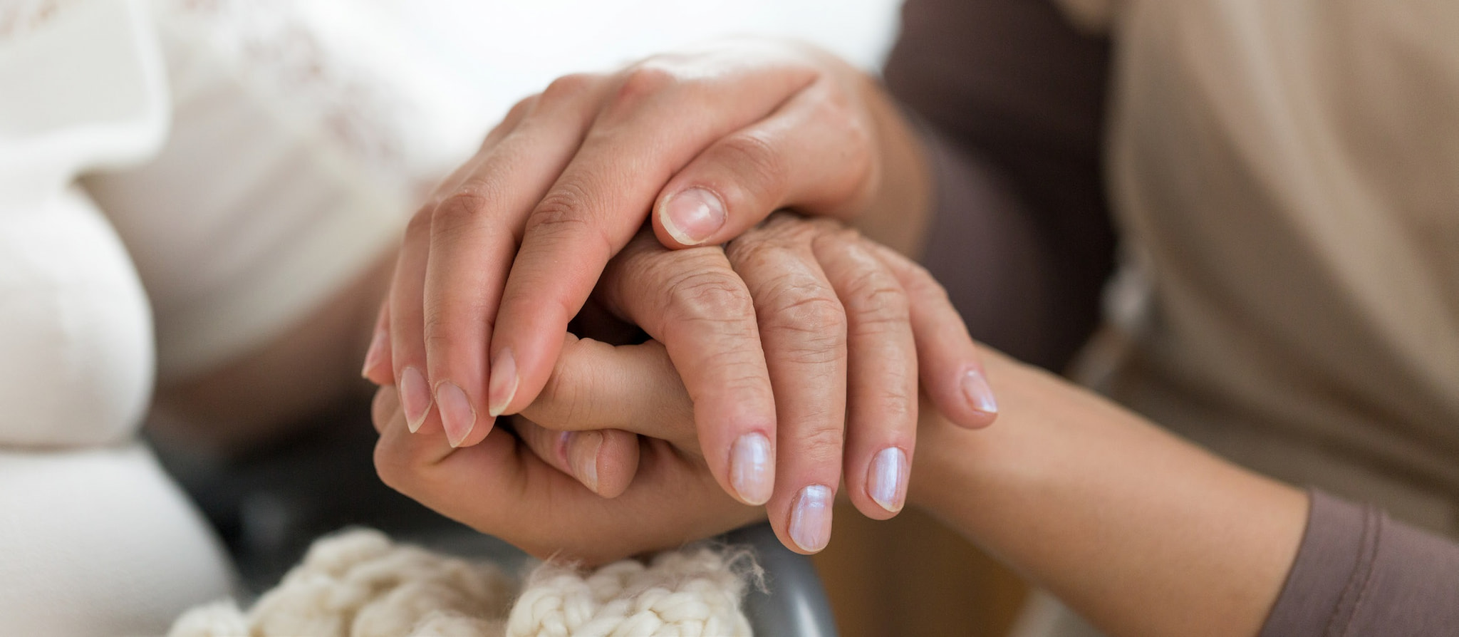 hospice woman holding elderly woman's hands