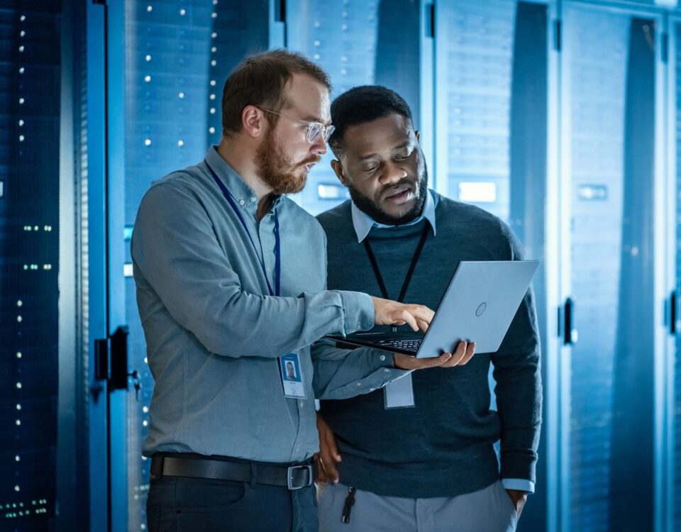 two IT men in a data centre looking at a laptop