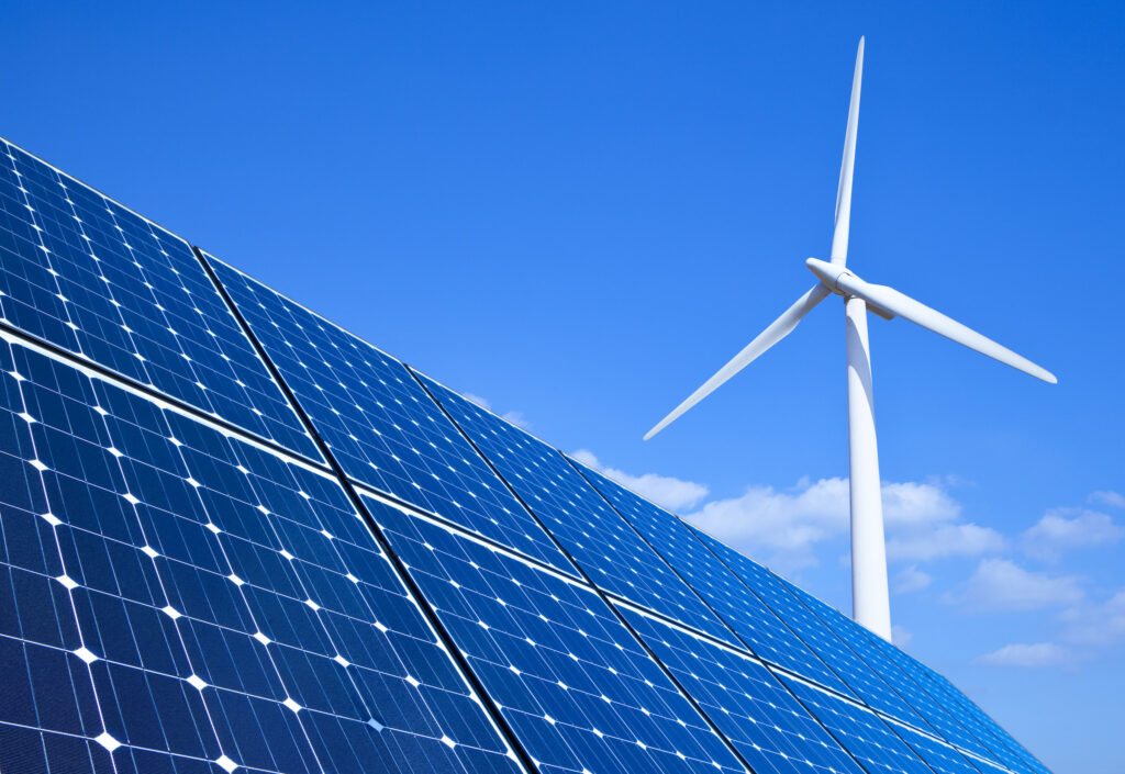 green energy solar panels wind turbine blue sky