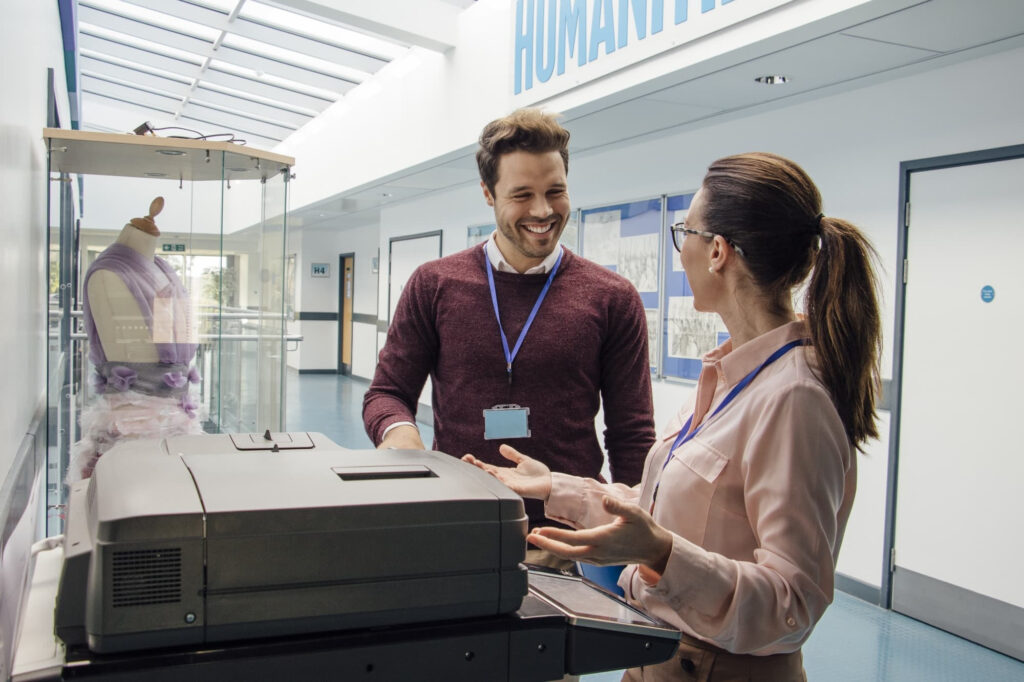 man and woman using printer photocopier in university