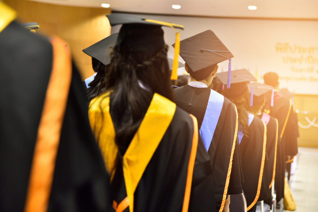 university graduates on graduation caps gowns gold sashes