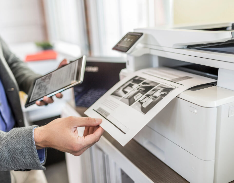 hand holding printed document from HP office printer photocopier