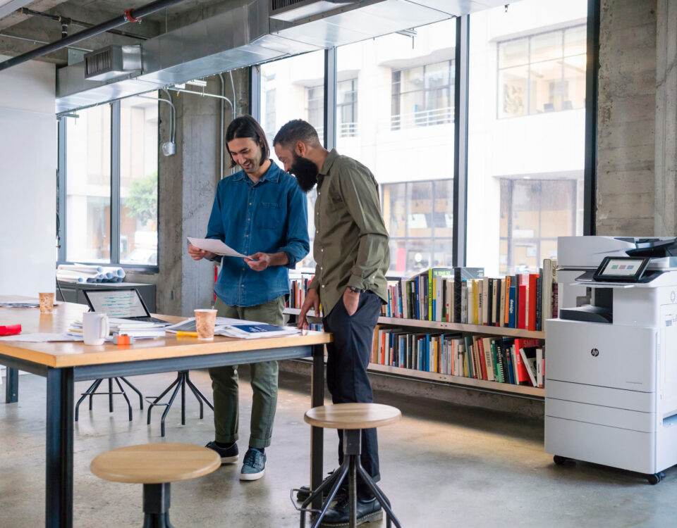 two men at office table large windows managed print services