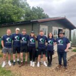 Apogee marketing team volunteering at charity Communigrow, standing in front of newly painted HQ