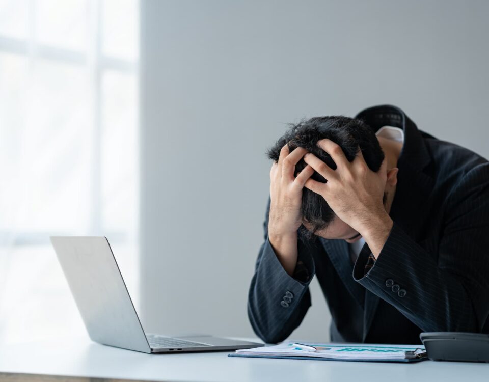 man at computer clutches his head in frustration