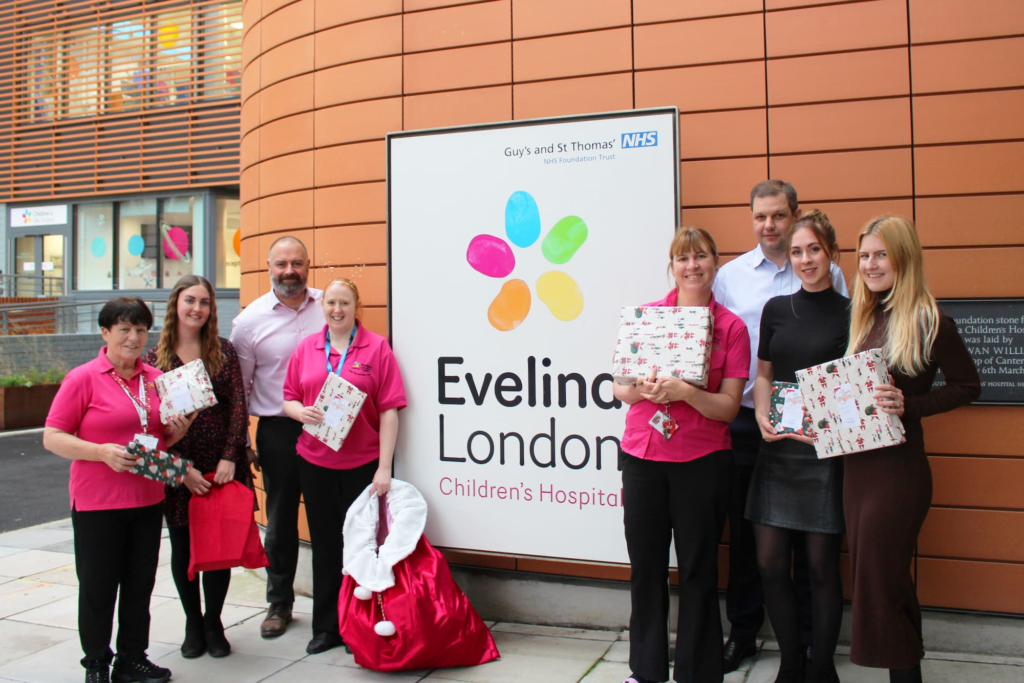 The Apogee and Guy's and St Thomas' team by the Evelina London Charity sign