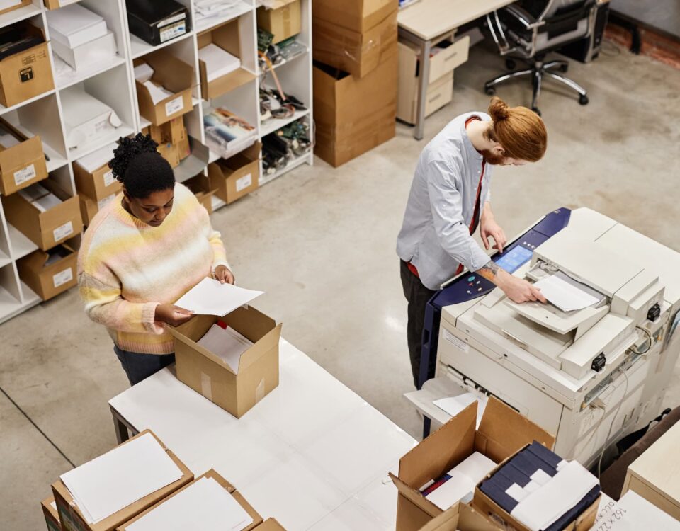 worker scanning while colleague packs boxes