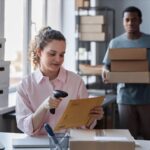 female-worker-of-storage room scanning packed envelope