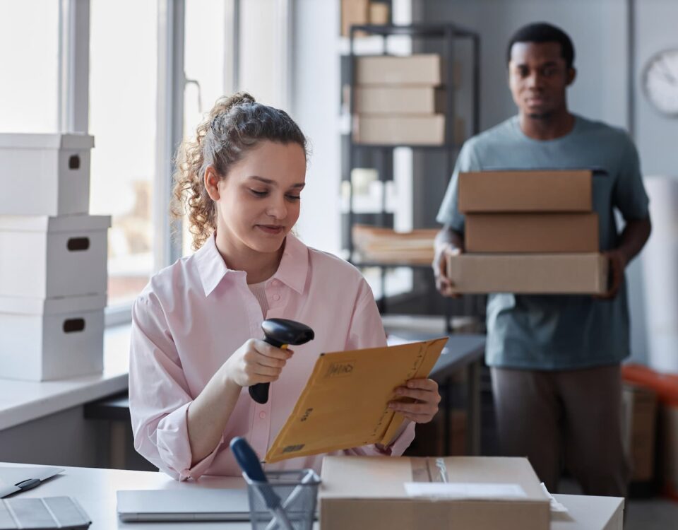 female-worker-of-storage room scanning packed envelope