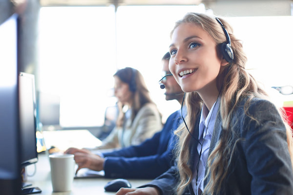 blonde woman smiling headset helpdesk customer support help centre