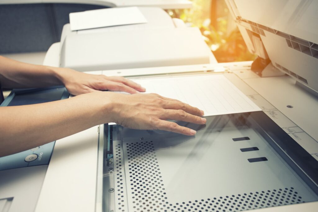 woman scanning a document on an office printer scanner