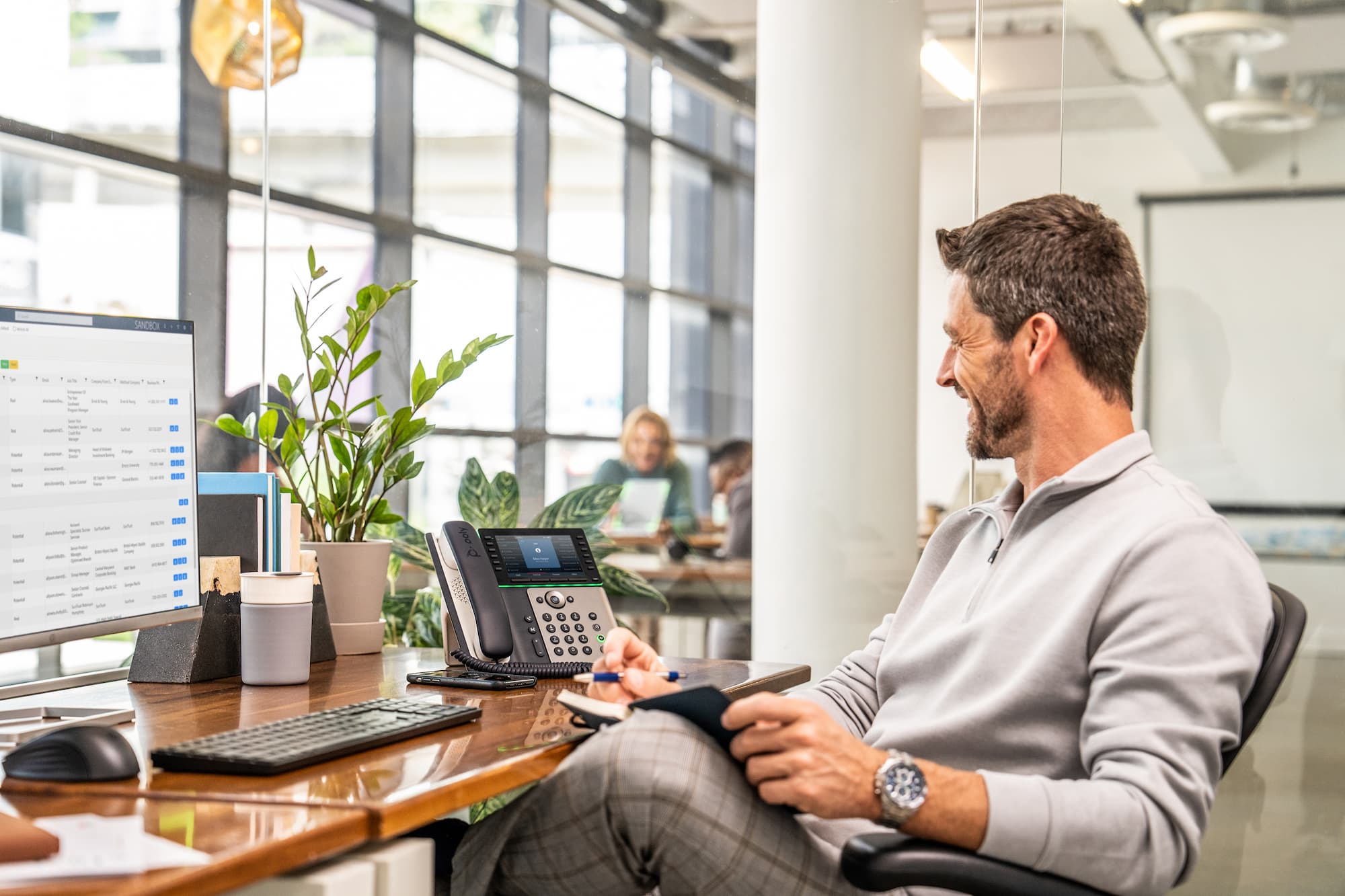 man at desktop using poly telecoms setup