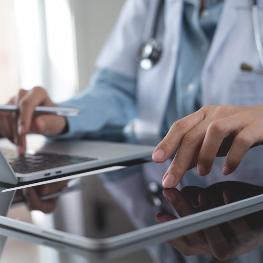 healthcare doctor in office using a laptop and tablet