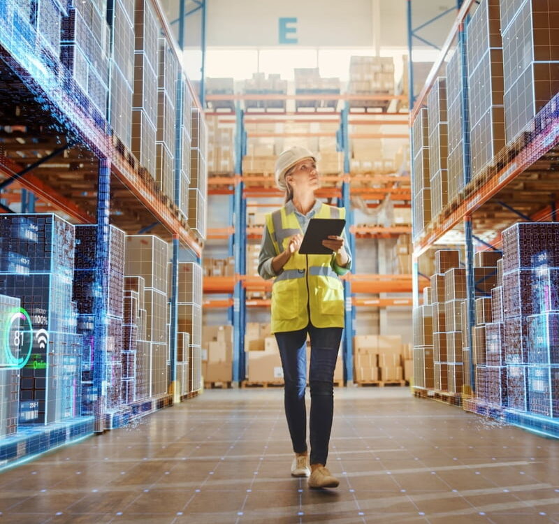 yellow vest warehouse worker woman taking inventory with laptop