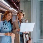 nhs staff two women nurse and business woman holding laptop