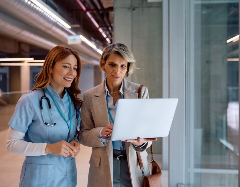 nhs staff two women nurse and business woman holding laptop