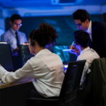 female it support technician pointing at monitor