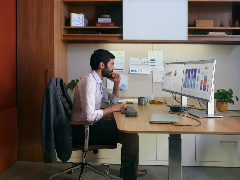 man sitting at finance desk HP monitor